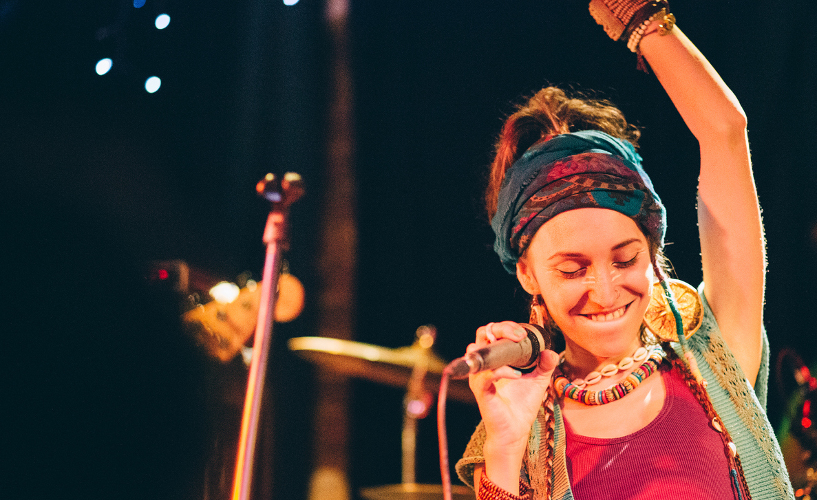 These 6 Tips Mean Success for High School Artists Young female singer on the stage with microphone.