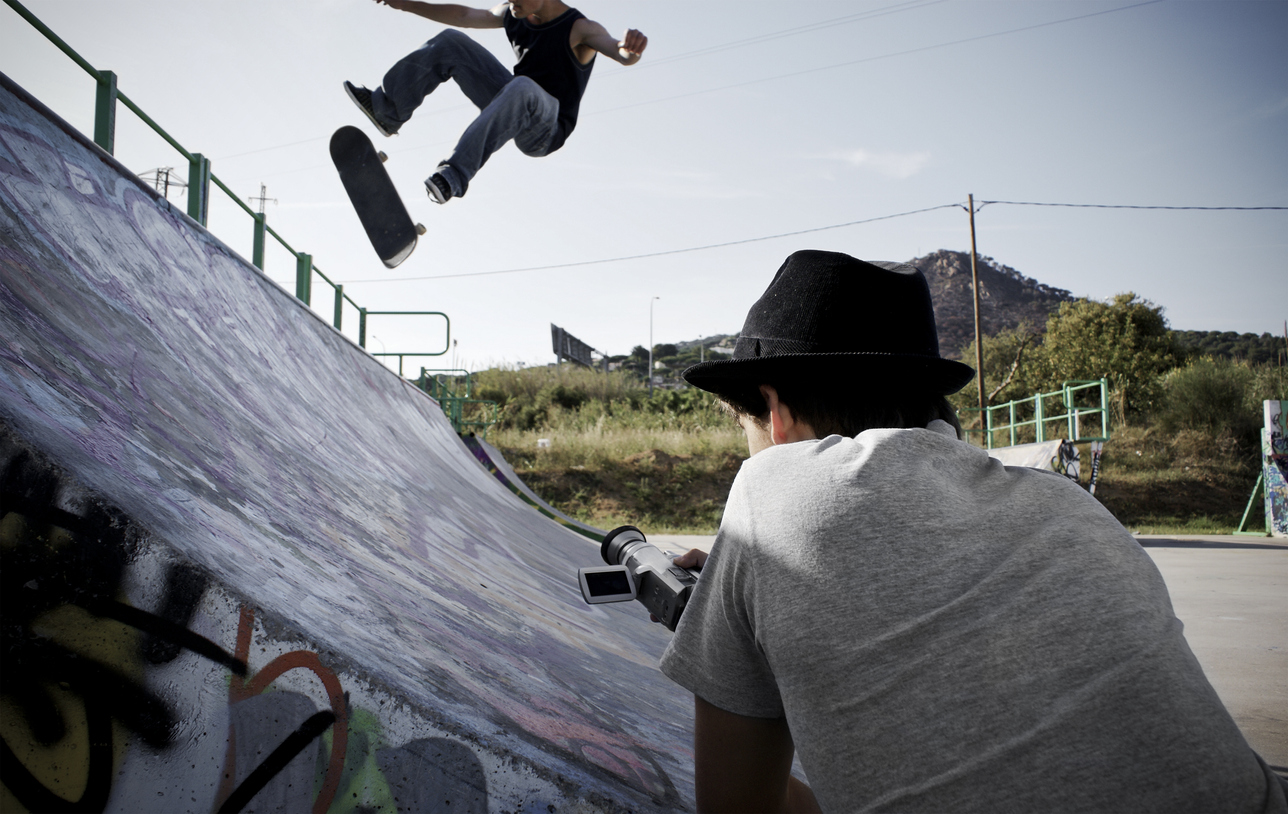 Find A Career in Film Outside of Hollywood Teen filming skateboarder doing a kickflip on a halfpipe.