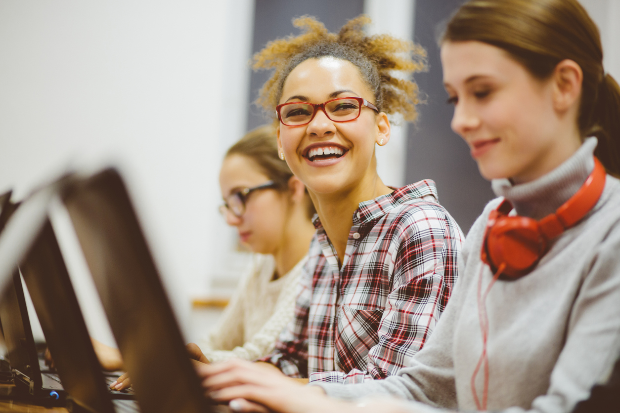 How Colleges Are Turning Computer Sciences Into A Girl Thing Afro-american woman in computer programming class and smiling