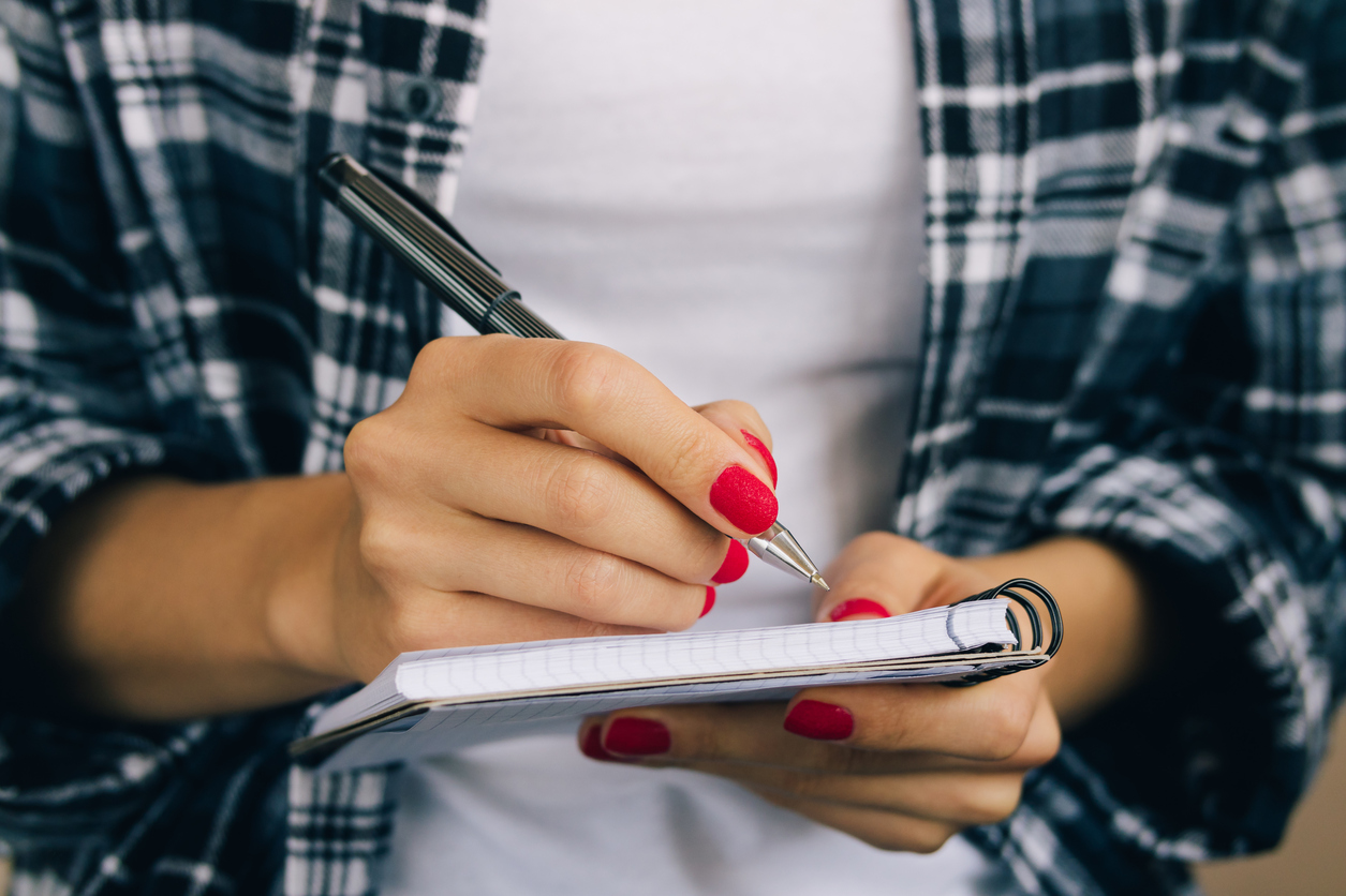 How to Craft the Perfect College Application List YOUng woman with red nails making a college list.