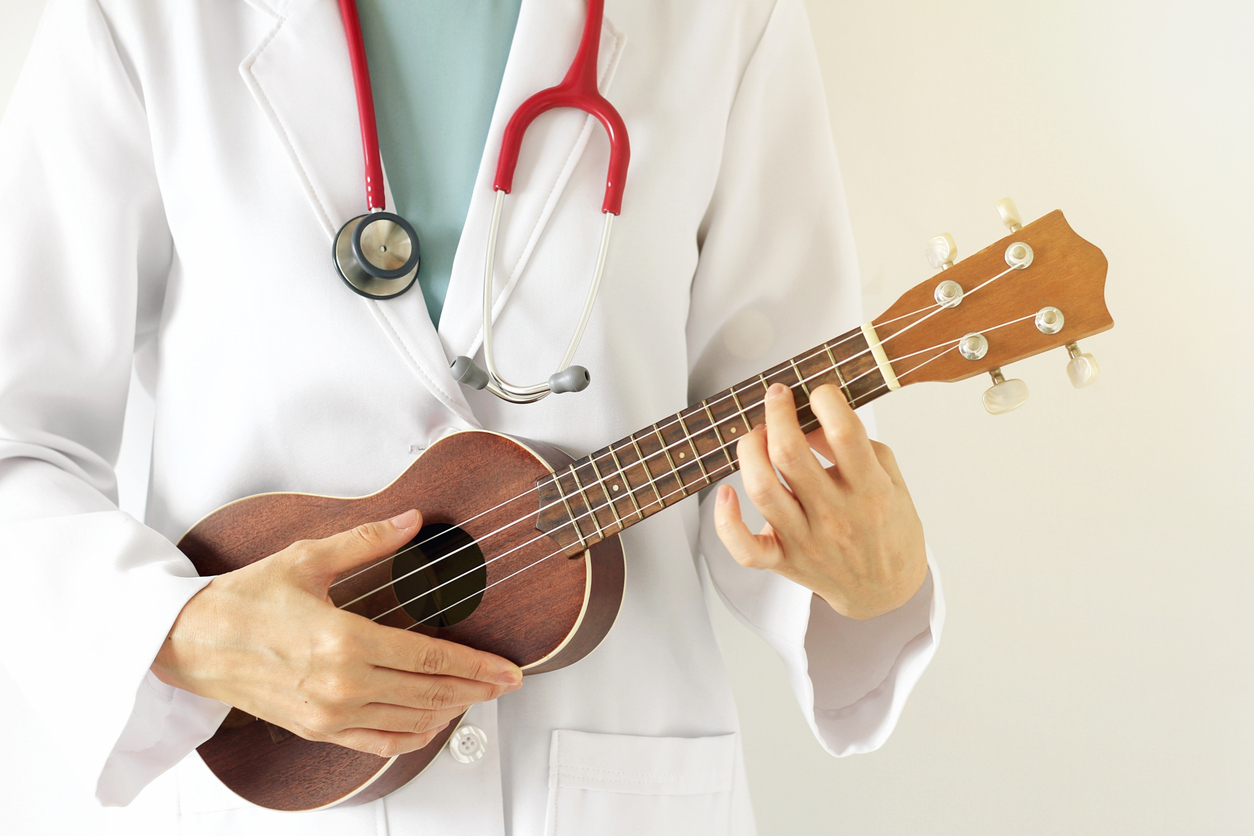 STEM and Music? Yes! It's Possible to Do That Double Major Doctor playing ukulele and wearing white coat.