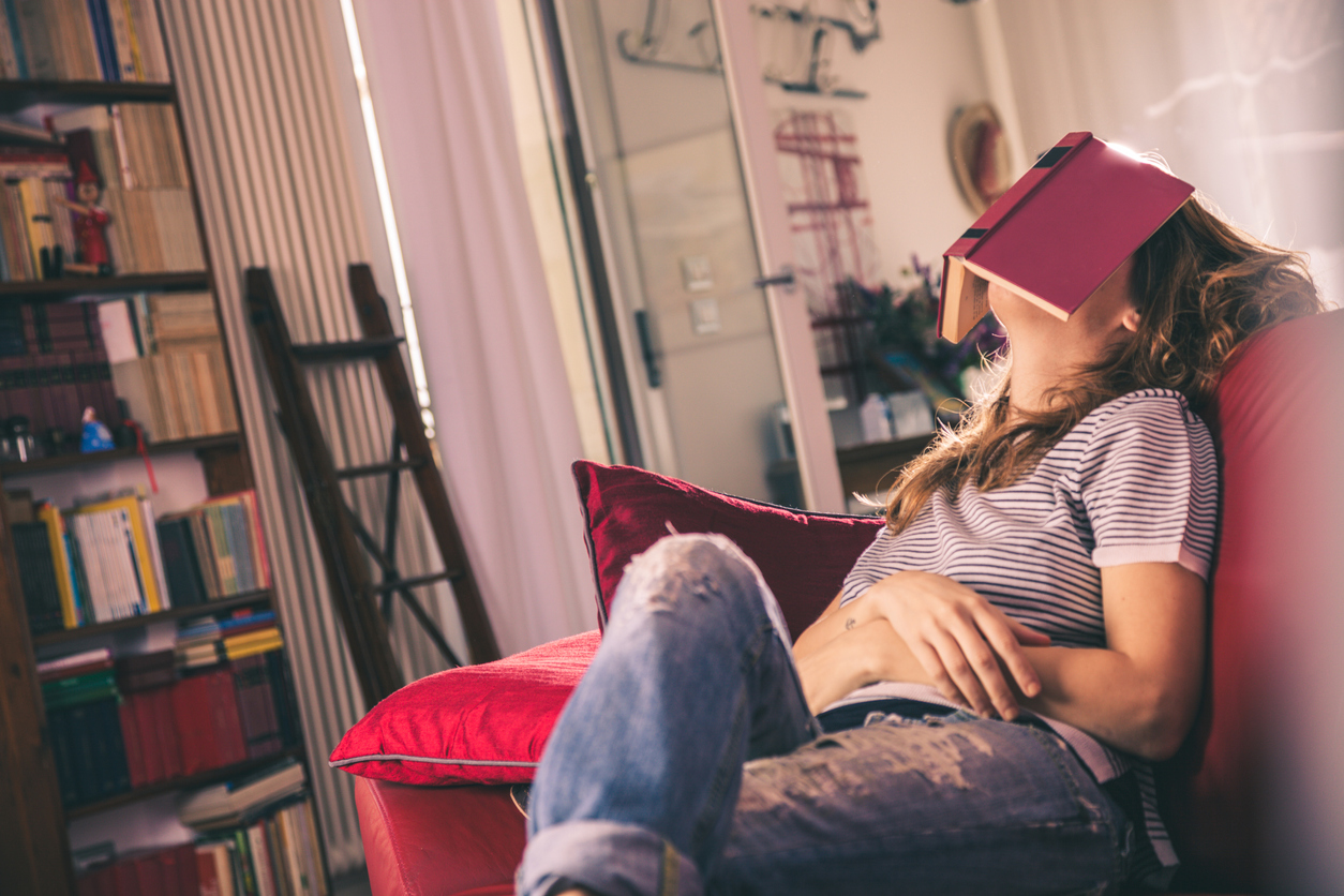 Gap Years and Other Ideas For Teens Unsure About College Young woman asleep on couch with book over her head.