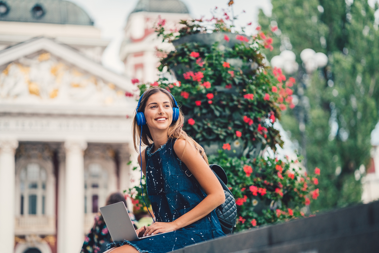 Why These Summer Courses Could Help You Get Into College Young woman studying outside on a college campus in the summer.
