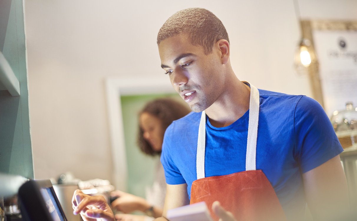Why Teens Should Really Get a Job This Summer Coffee shop worker with digital order screen